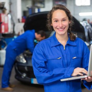 View of a Young attractive woman mechanic working at the garage